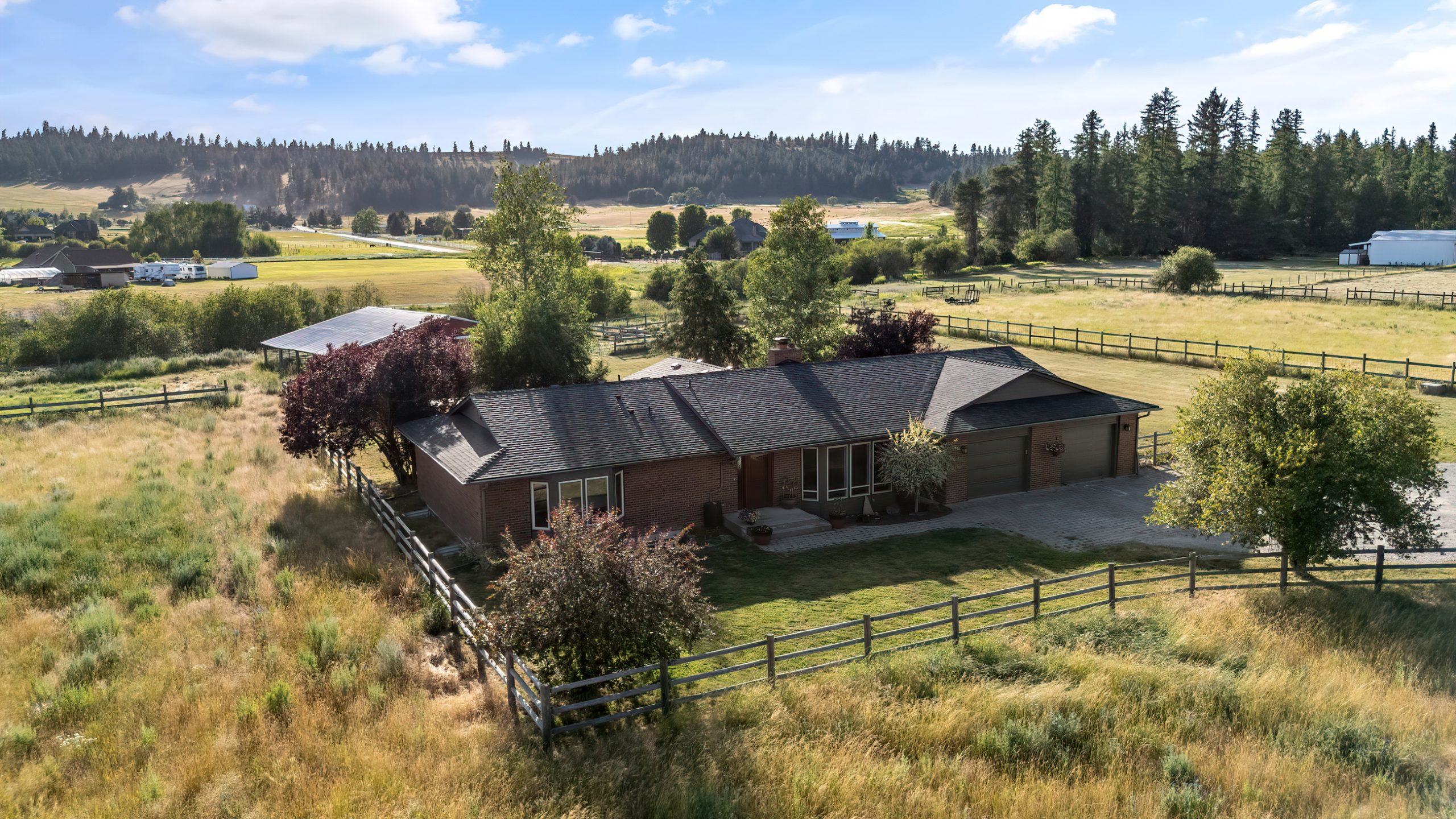 Aerial view of the home at 17207 N Mt. Spokane Park Drive in Mead, surrounded by fenced pasture and rural foothills.